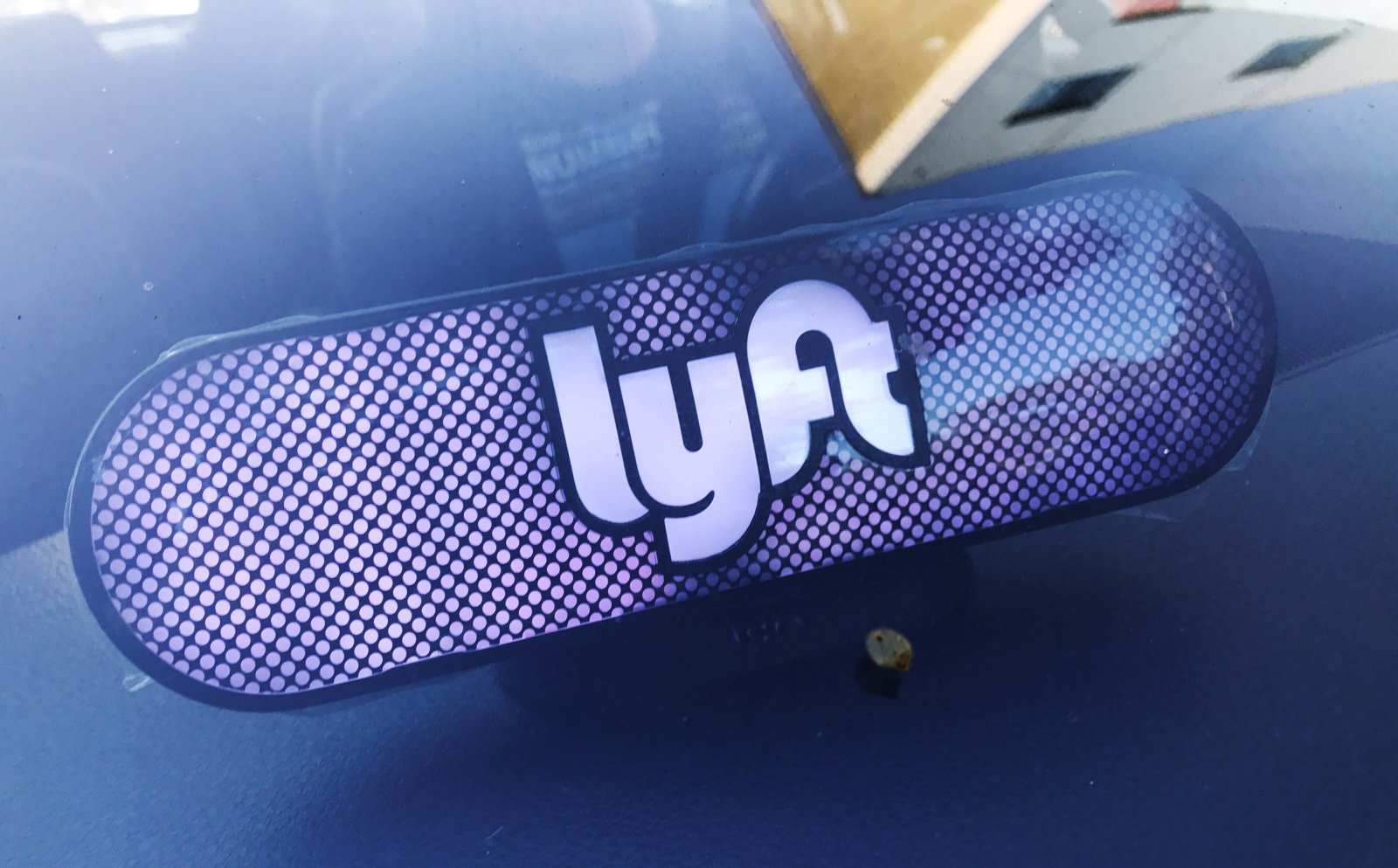 An illuminated sign appears in a Lyft ride-hailing car in Los Angeles